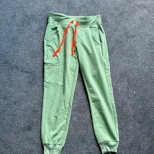 Figs petite XS light teal jogger scrub bottoms with orange drawstring tie.